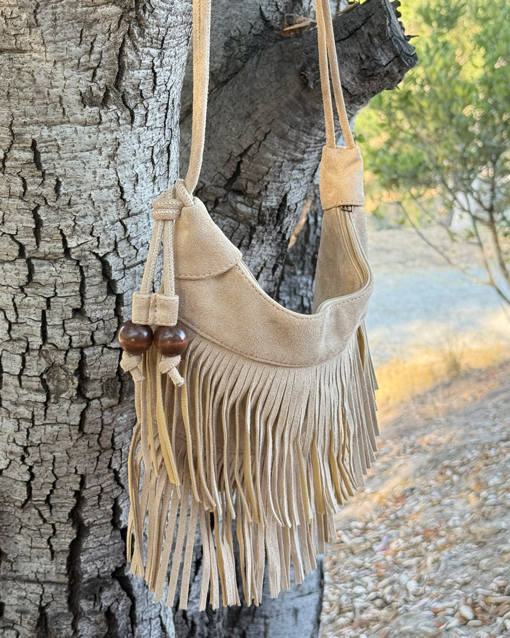 Product image featuring the River Run Fringe Bag in brown.​